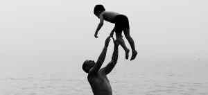 man throwing son in water